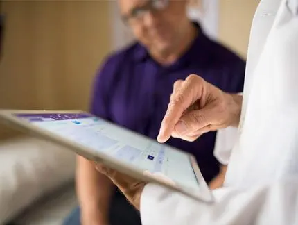 doctor using iPad while interacting with patient