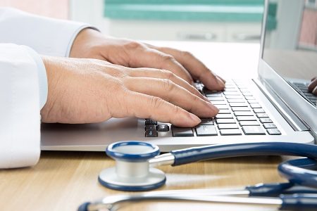 Close up of doctor's hand at computer typing
