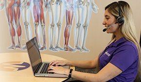 smiling mips advisor uses laptop while talking into headset