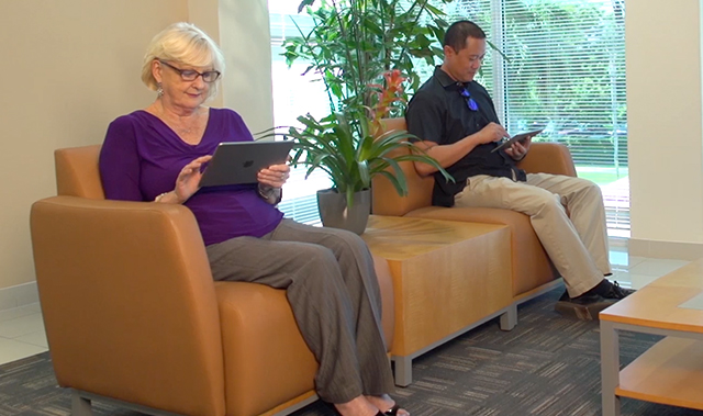 Female and Male patient in waiting room on iPads