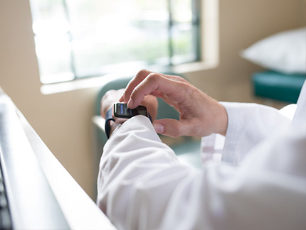 doctor in office using PocketEMA app on Apple Watch to view messages