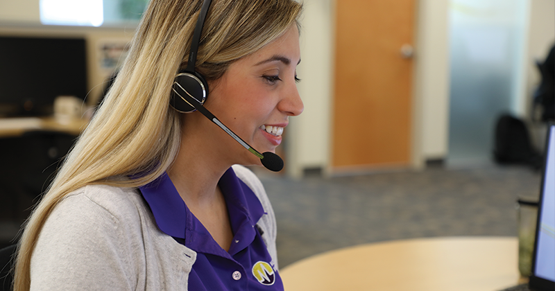 female employee smiling and wearing a headset