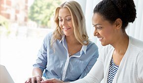 two women working together on a laptop