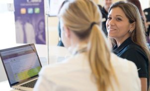 Support staff member assisting a client on a laptop