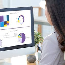 female staff member looking at analytics reports on imac female staff member looking at analytics reports on imac