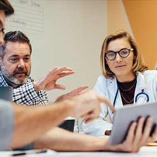 physician with stethoscope typing on a laptop on a gastroenterology portal login screen