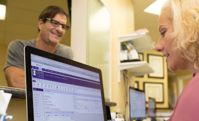 patient at front desk while staff uses practice management