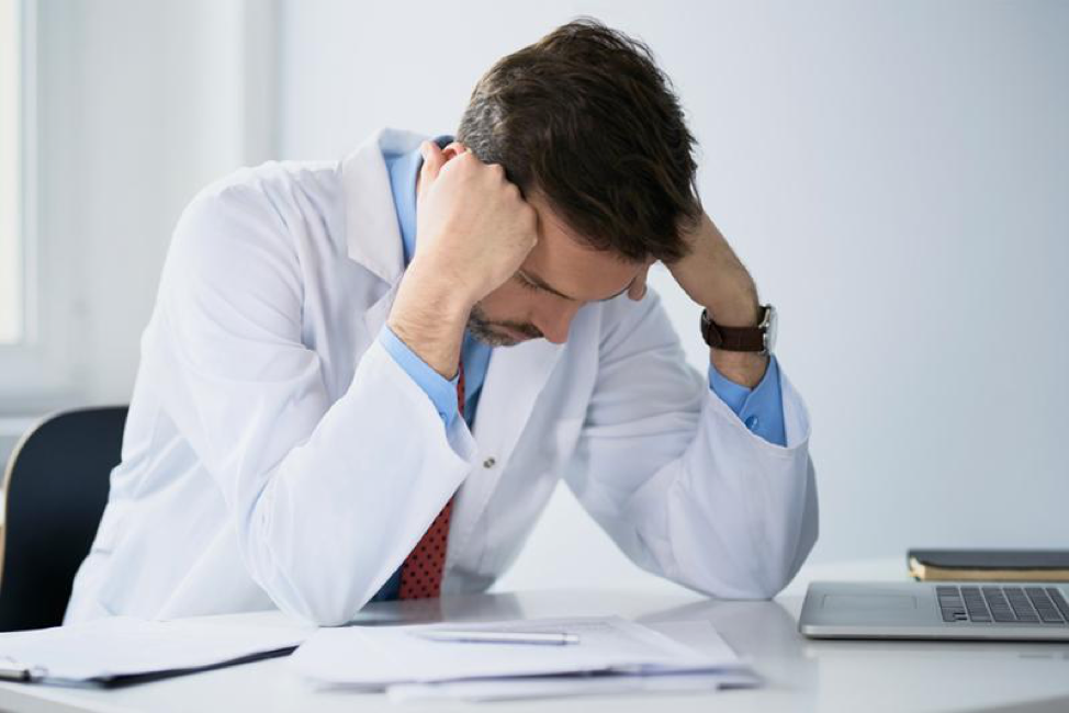 frustrated-ophthalmologist-with-hands-on-hand-at-desk