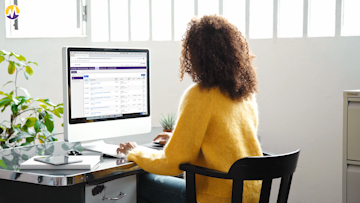 Staff member checking inventory on a computer 