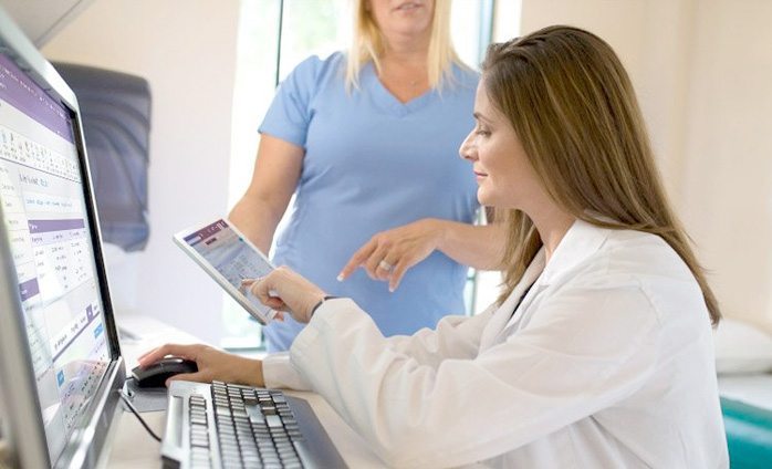 Physician and assistant reviewing data on an iPad 