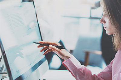 Staff member reviewing accounts on a screen 