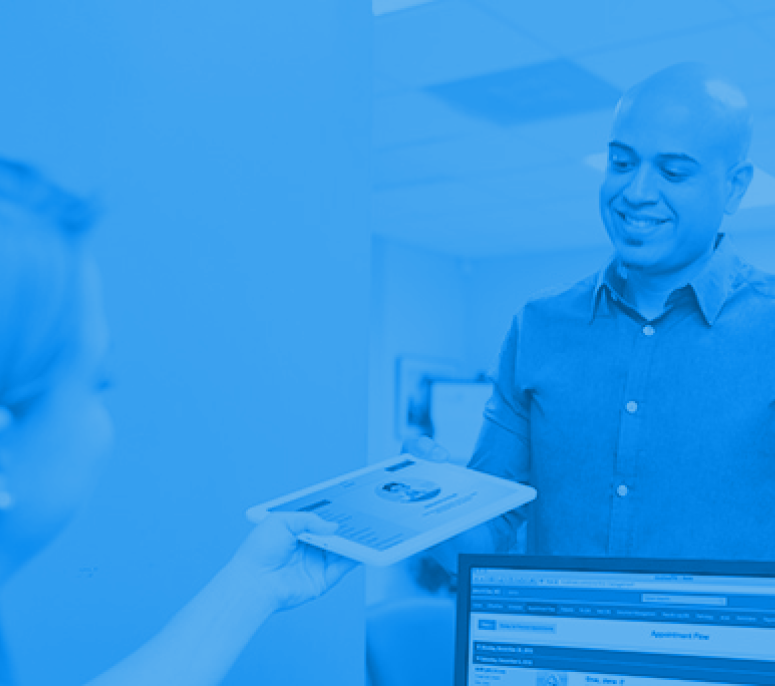 ModMed Kiosk Copay Collection Patient handing iPad to front desk after paying a copay in the office