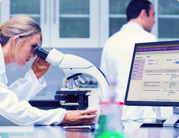 Lab professionals reviewing specimens through a microscope.