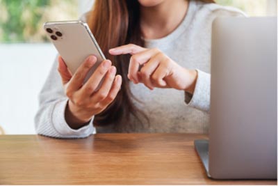 Woman uses her cell phone to schedule a doctor’s appointment.