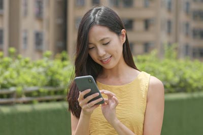 Woman uses cell phone to text.