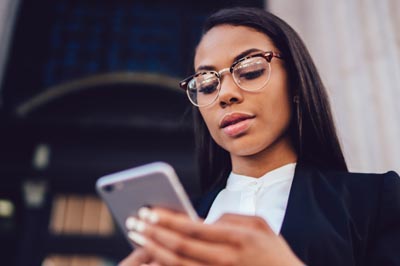 Women uses cell phone to complete a patient survey.