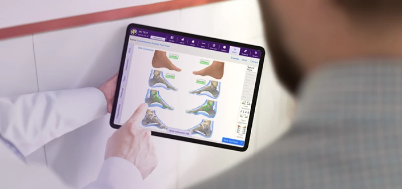 A podiatrist showing diagrams on tablet to a patient