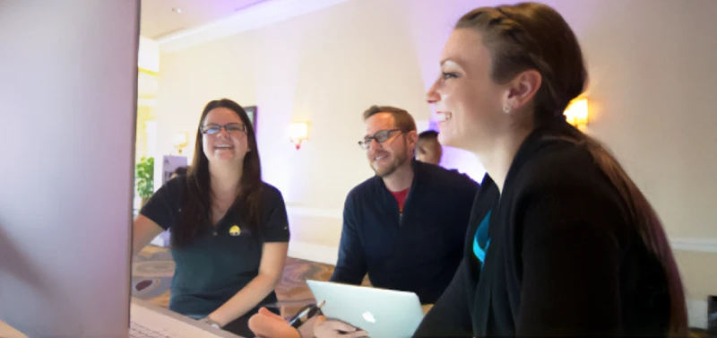 3 coworkers looking at large format screen