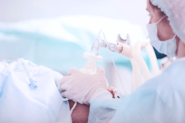 An anesthesiologist administers medication to a patient.
