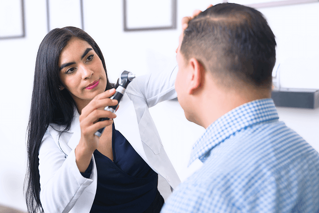 An ophthalmologist examines a man’s eyes.
