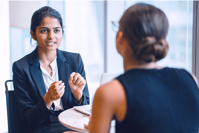 A practice administrator speaking with another medical professional in a clinical setting.