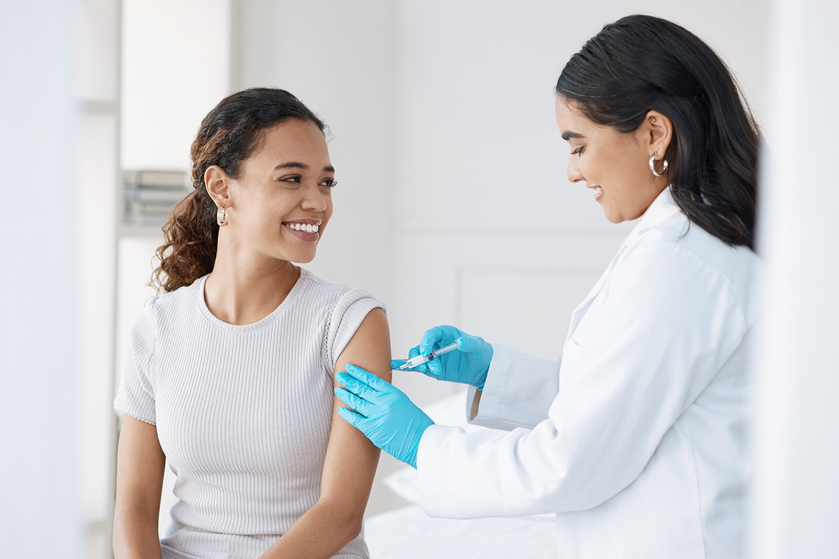 A physician administers an allergy shot to a smiling patient, a visit that will be documented in the patient's EHR.