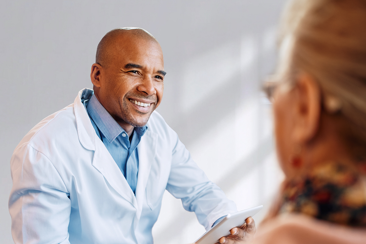 A physician uses a mobile EHR on a tablet to facilitate a positive and engaging consultation with a patient.