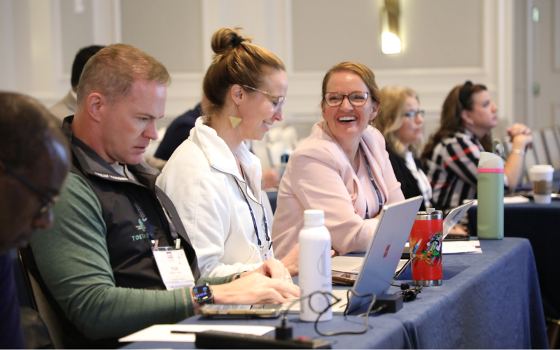 MOMENTUM attendees with laptops open at a training session.